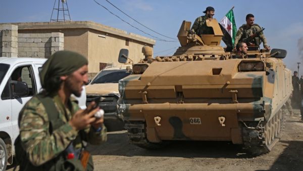 Turkish-baked Syrian fighters drive an armoured personnel carrier near the Syrian border town of Tal Abyad on October 12, 2019, as they prepare to take part in the Turkish-led assault on northeastern Syria. Bakr ALKASEM / AFP