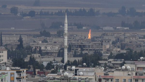 Turkish side of the border with Syria in the Ceylanpinar district city of Sanliurfa shows a fire rising from the Syrian town of Ras al-Ain (AFP)