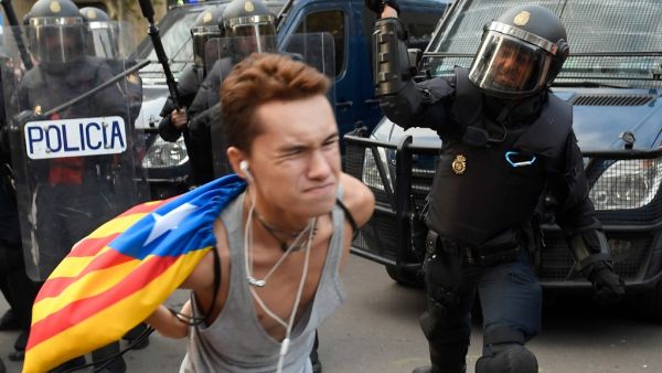 A Spanish national police officer uses his club to hit a protester during a demonstration called the Catalan pro-independence left youth group 'Arran' (AFP) A Spanish national police officer uses his club to hit a protester during a demonstration called the Catalan pro-independence left youth group 'Arran' (AFP)
