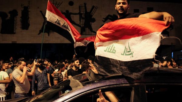 Iraqi protestors wave Iraq's national flags frome a car;s sun-roof as they take part in anti-government demonstrations in Baghdad's Tahrir Square on October 24, 2019. Anti-government rallies renewed across Iraq late on October 24, 2019, the second phase of protests denouncing corruption and unemployment before evolving into calls for an overhaul of the political system that turned deadly earlier this month and which could balloon after the endorsement of populist cleric Moqtada al-Sadr. AFP