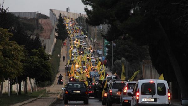 Supporters of the Shiite Hezbollah movement drive in a convoy in support of its leader Hassan Nasrallah's speech, in the area of Fatima's Gate in Kfar Kila on the Lebanese border with Israel on October 25, 2019. (AFP)