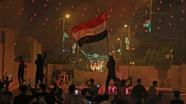 An Iraqi protester waves the national flag during an anti-government demonstration in the Shiite shrine city of Karbala, south of Iraq's capital Baghdad, on October 25, 2019. Two dozen demonstrators were killed in renewed rallies across Baghdad and Iraq's south today by live rounds and tear gas, according to a national rights watchdog. AFP