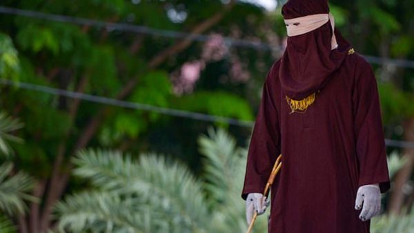 A member of the Sharia police can be seen standing ahead of the public caning in Banda Aceh on October 21, 2019 (AFP/dailymail.co.uk)