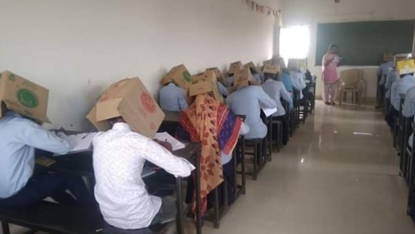 Students wearing cardboard boxes on their heads during an exam to discourage cheating (Twitter)