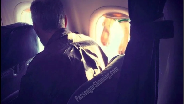 An unidentified plane passenger is leaving netizens disgusted after he was captured drying his socks by wedging them in the plane's window shutter. (Photo: Passenger Shaming/Instagram)