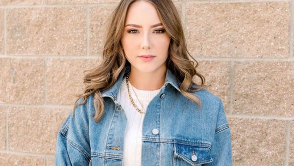 Hailie covered up in a thigh-length forest green dress which was covered in a white and black plaid print. 