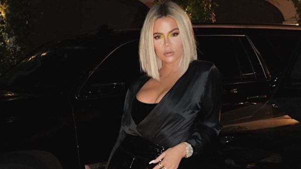 Kardashian can be seen taking the picture on her phone as she poses in a hallway.