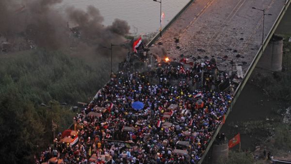 Iraqi protesters gather on al-Jumhuriya bridge which leads to the high-security Green Zone, during ongoing anti-government demonstrations in the capital Baghdad on October 31, 2019. Iraq's president vowed today to hold early elections in response to a month of deadly protests, but demonstrators said the move fell far short of their demands for a political overhaul. AHMAD AL-RUBAYE / AFP