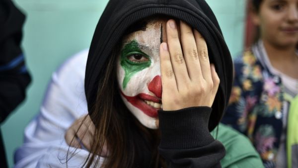 An Algerian demonstrator wearing face paint in the colours of the national flag takes part in an anti-government demonstration in the capital Algiers   RYAD KRAMDI / AFP