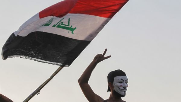 An Iraqi protester, wearing the Guy Fawkes mask, flashes the V for victory sign during ongoing anti-government demonstrations (AFP)