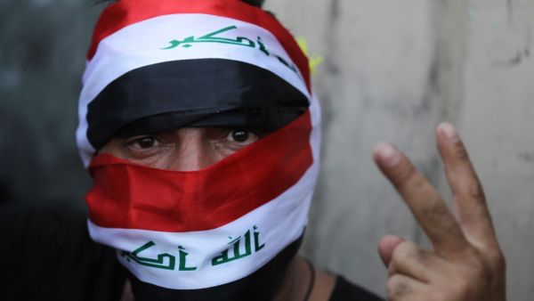 An Iraqi protester flashes the victory sign during ongoing anti-government demonstrations on al-Jumhuriya bridge which leads to the high-security Green Zone, in the capital Baghdad on November 2, 2019. Iraqi security forces clashed with anti-government protesters in the early hours of Saturday near the capital's Tahrir Square, leaving one demonstrator dead and dozens more wounded, medical sources said. AHMAD AL-RUBAYE / AFP