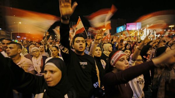 Lebanese protesters wave flags and shout slogans during an anti-government demonstration at al-Nour Square in the northern port city of Tripoli on November 2, 2019. Ibrahim CHALHOUB / AFP