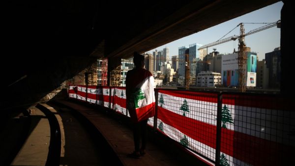A Lebanese student clad with the national flag looking at the downtown area of the capital Beirut from within The Egg (the Dome), an unfinished cinema structure built in 1965, amid ongoing anti-government demonstrations. Thousands of students took to the streets across Lebanon today to demand a better future as an unprecedented anti-government protest movement entered its fourth week and continued to spread. Patrick BAZ / AFP