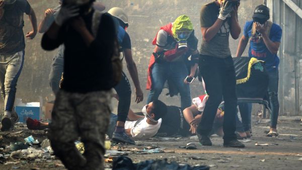 Iraqi protesters react to tear gas amid clashes with security forces at Baghdad's Khallani square during ongoing anti-government demonstrations on November 12, 2019. (AFP/ File Photo)