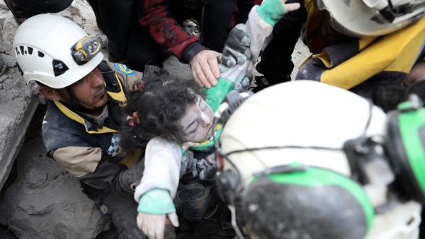 Syrian rescue workers known as the 'White Helmets' and residents remove body of a child from under the rubble of a building destroyed by a reported Russian airstrike on the village al-Barra in the southern countryside of Syria's northern Idlib province on November 15, 2019. (Omar HAJ KADOUR / AFP)
