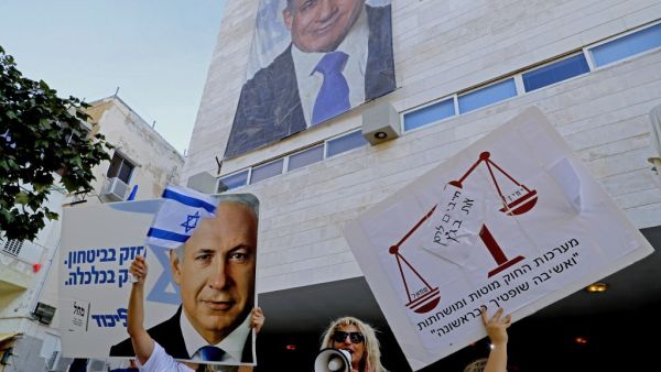 Supporters of Israeli Prime Minister Benjamin Netanyahu chant slogans and hold up signs in support of him during a counter-rally outside the Likud party headquaters in the coastal Mediterranean city of Tel Aviv on November 22, 2019. (AFP)