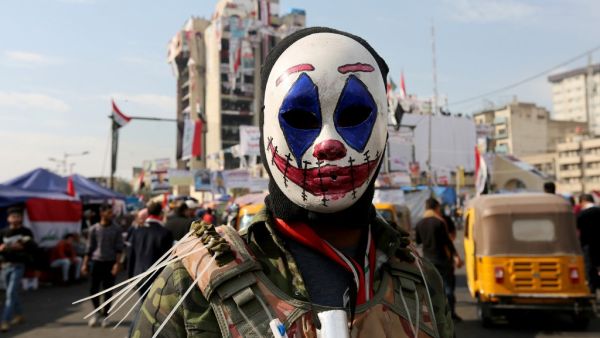 An Iraqi protester wearing the DC comic Joker character's mask poses for a picture during an anti-government demonstration in the capital Baghdad, on November 23, 2019. SABAH ARAR / AFP