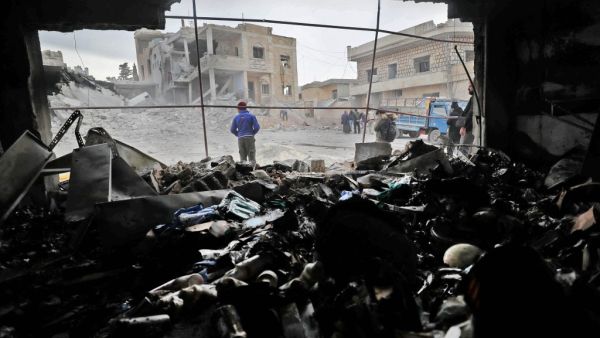 Syrians walk amidst rubble following reported airstikes by pro-regime forces in the town of Kansafrah, in the south of the Idlib province on November 25, 2019. (Omar HAJ KADOUR / AFP)