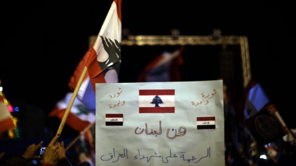 A Lebanese anti-government protester holds a placard readingin Arabic “From Lebanon to Iraq”, during a rally in the capital Beirut's downtown district on November 30, 2019. More than a month into unprecedented anti-government protests, Lebanon is facing a dual political and economic crisis. Patrick BAZ / AFP