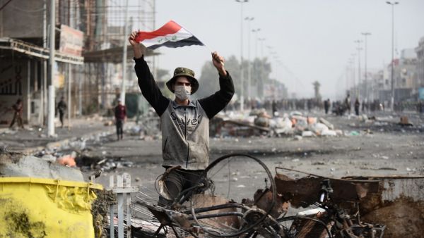 An Iraqi demonstrator carries the national flag in the southern Iraqi Shiite holy city of Najaf (AFP)