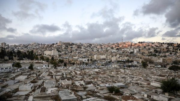 City of Hebron in the occupied West Bank shows a view of a Palestinian cemetery (foreground), an old market building (C) along al-Shuhada street that was newly-announced by the Israeli defence minister to be designated as a new settlement, with existing Israeli settler buildings behind (AFP) 