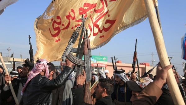 Armed members of Karbala clans lift their guns as they take to the streets to declare their support to the Iraqi armed forces to prohibit trouble makers from entering the southern Shiite shrine city on December 8, 2019. (AFP/ File Photo)
