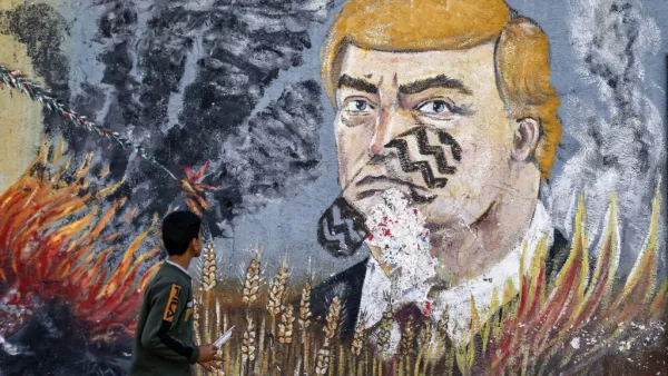 A boy looks at a graffiti mural depicting US President Donald Trump  (AFP)
