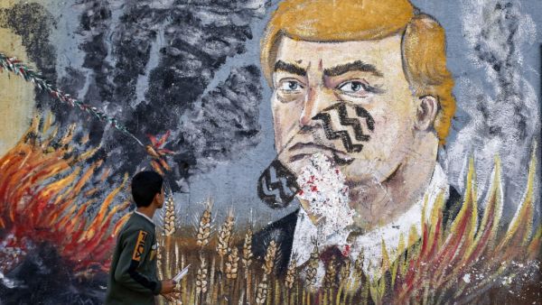 A boy looks at a graffiti mural depicting US President Donald Trump  (AFP)