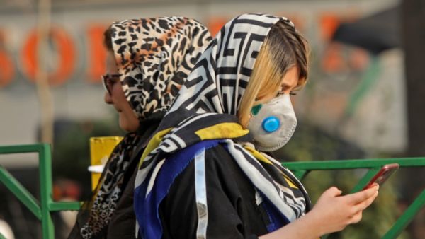 An Iranian woman walks with a mask to protect herself from air pollution on December 23, 2019 in the Iranian capital Tehran. Schools in Iran's Tehran province have been ordered shut until due to severe air pollution, authorities announced, extending their closure to a full week. Tehran city was cloaked by thick toxic smog for a third successive day on Monday that blanketed out landmarks like Milad Tower and the snow-capped Alborz mountains. ATTA KENARE / AFP