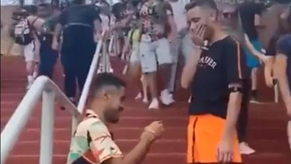 Two men kiss on the steps below a Ferris wheel before one man pulls out a ring (dailymail)