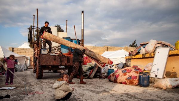 Syrians, among those who fled from government forces' advance on Maaret al-Numan in the south of Idlib prvoince, unload a rolled-up carpet from a truck at a camp for the displaced near the town of Dana in the province's north near the border with Turkey, on December 27, 2019. Aaref WATAD / AFP