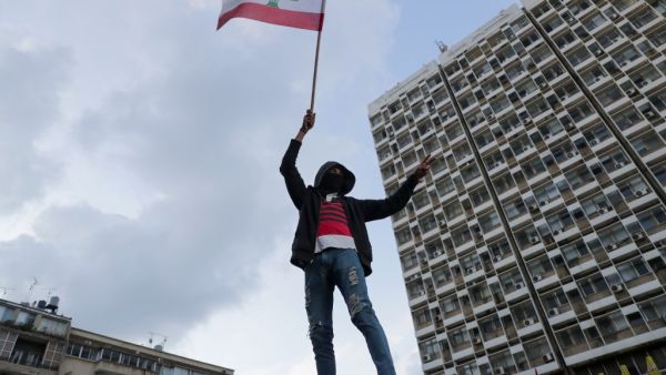 A Lebanese demonstrator waves the national flag during a demonstration outside the Electricite du Liban (Electricity Of Lebanon) national company headquarters in the Lebanese capital Beirut on January 11, 2020.(AFP/ File Photo)