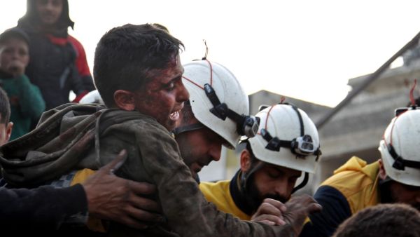 Members of the Syrian Civil Defence, also known as the White Helmets, recover a wounded boy from the rubble of a building following a regime air strike on a vegetable market in Syria's last major opposition bastion of Idlib on January 15, 2020. (AFP/ File Photo)