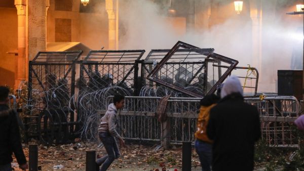 Anti-government protesters attempt to break through the security barrier in the central downtown district of the Lebanese capital Beirut near the parliament headquarters during clashes with security forces on January 18, 2020. ANWAR AMRO / AFP