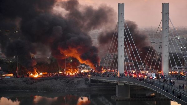 Iraqi Anti-government demonstrators block a bridge with debris and burning tires in the southern Iraqi city of Nasiriyah on January 19, 2020. AFP