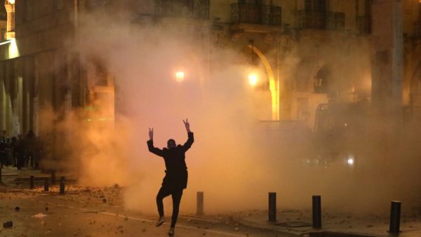 A Lebanese protester gestures at riot police guarding a road leading to parliament in central Beirut on January 19, 2020 amid ongoing anti-government demonstrations. PATRICK BAZ / AFP