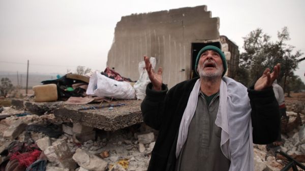A Syrian man gestures as he stands next to the rubble of the house where he lived with his displaced family in the village of Kafr Taal, in Aleppo's western countryside, after a reported pro-regime bombardment, on January 20, 2020. Aaref WATAD / AFP