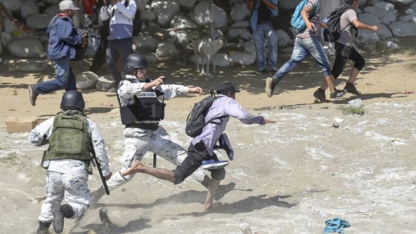 Hundreds of Central Americans from a new migrant caravan tried to enter Mexico by force Monday by crossing the river that divides the country from Guatemala, prompting the National Guard to fire tear gas, an AFP correspondent said. Johan ORDONEZ / AFP