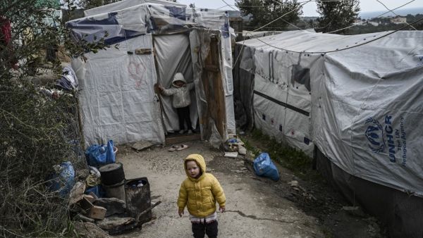 A child stands at a makeshift camp next to the refugee camp of Moria, in the island of Lesbos on January 21, 2020. Greece's conservative government reinstated the migration ministry six months after scrapping it, amid frantic efforts to relocate thousands of asylum seekers from dismal island camps. ARIS MESSINIS / AFP