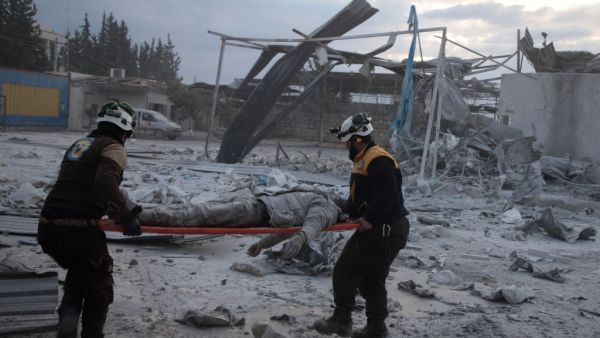 Members of the Syrian Civil Defence, also known as the White Helmets, load a body onto a stretcher following a reported airstrike on the village of Kafr Naha, in the western countryside of the northern province of Aleppo, on January 21, 2020. (AFP/ File Photo)