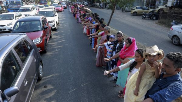 People line up along a road to form a 620 km human chain across the southern state of Kerala organized by the Left Democratic Front (LDF) to protest against the Indian government's Citizenship Amendment Act (CAA), in Kochi on January 26, 2020. STR / AFP