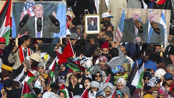 Pro-Palestinian protesters wave Palestinian and Moroccan flags next to posters of the US President Donald Trump and Israeli Prime Minister covered in shoes in a sign of disrespect during a demonstration in Rabat, Morocco on 10 December 2017 [FADEL SENNA/AFP/Getty Images]