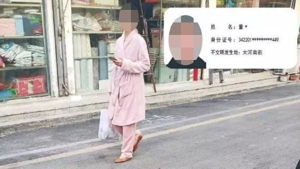 The picture posted by Suzhou City Urban Management Bureau in eastern China and obscured by MailOnline shows one woman walking on a street in the city while wearing a pink robe. (Daily Mail)