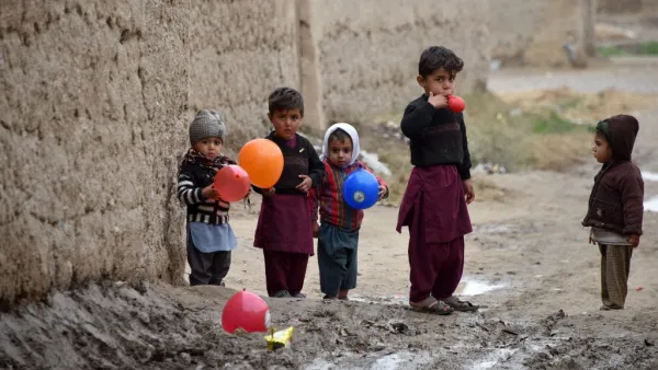 Children play with balloons along a street in Kandahar Province on January 28, 2020. JAVED TANVEER / AFP