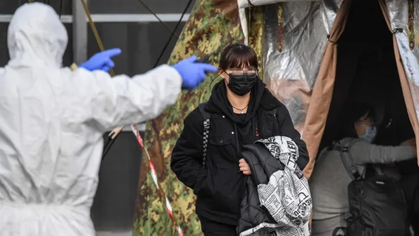 An Italian citizen (C) repatriated from the coronavirus hot-zone of Wuhan is directed to a health control zone after landing at the Mario De Bernardi military airport in Pratica di Mare, south of Rome, on February 3, 2020 prior to be placed in quarantine at the nearby Cecchignola center. ANSA / AFP