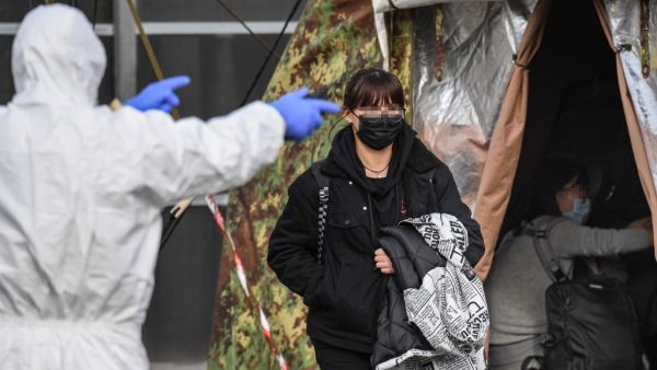 An Italian citizen (C) repatriated from the coronavirus hot-zone of Wuhan is directed to a health control zone after landing at the Mario De Bernardi military airport in Pratica di Mare, south of Rome, on February 3, 2020 prior to be placed in quarantine at the nearby Cecchignola center. ANSA / AFP
