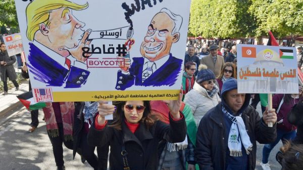 Arabic writing on placards reads: "Jerusalem is the capital of Palestine" (R) and "Down with the 'Deal of the Century', #Boycott" next to cartoon images of Trump and Israel's Prime Minister Benjamin Netanyahu. FETHI BELAID / AFP
