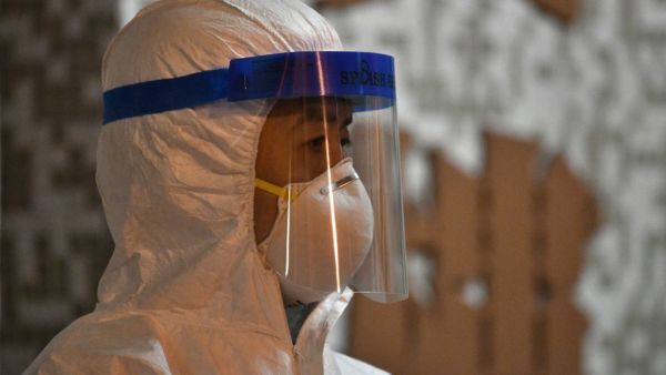 A medical personnel looks on as he stands in the ground of a residential estate, in Hong Kong, early on February 11, 2020, after two people in the block were confirmed to have contracted the coronavirus according to local newspaper reports. Anthony WALLACE / AFP