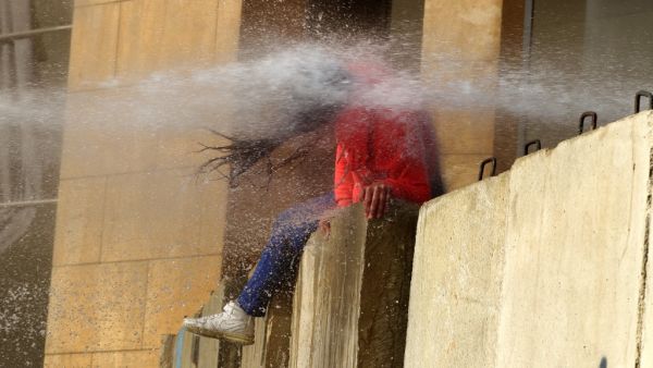 A Lebanese Protester is hit with a burst from a water cannon during clashes with army soldiers on February 11, 2020, as demonstrators gather in the heart of Beirut to stop a confidence vote for a new government, which they say fails to address their demands and cannot rescue the ailing country. Security forces used tear gas and water cannon to break up groups of demonstrators who hurled rocks over the blast walls erected around parliament. The Red Cross reported 24 people had been hospitalised and 147 treat