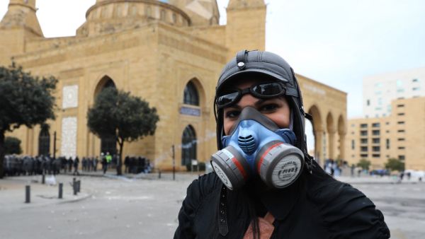 A Lebanese protester poses for a picture with a gas mask near clashes with security forces during a protest in the heart of Beirut to stop a confidence vote for a new government, which they say fails to address their demands and cannot rescue the ailing country, on February 11, 2020. Lebanon has been rocked by protests since October 17 demanding a complete overhaul of a political class which activists say is inept, corrupt and motivated by personal gain. ANWAR AMRO / AFP